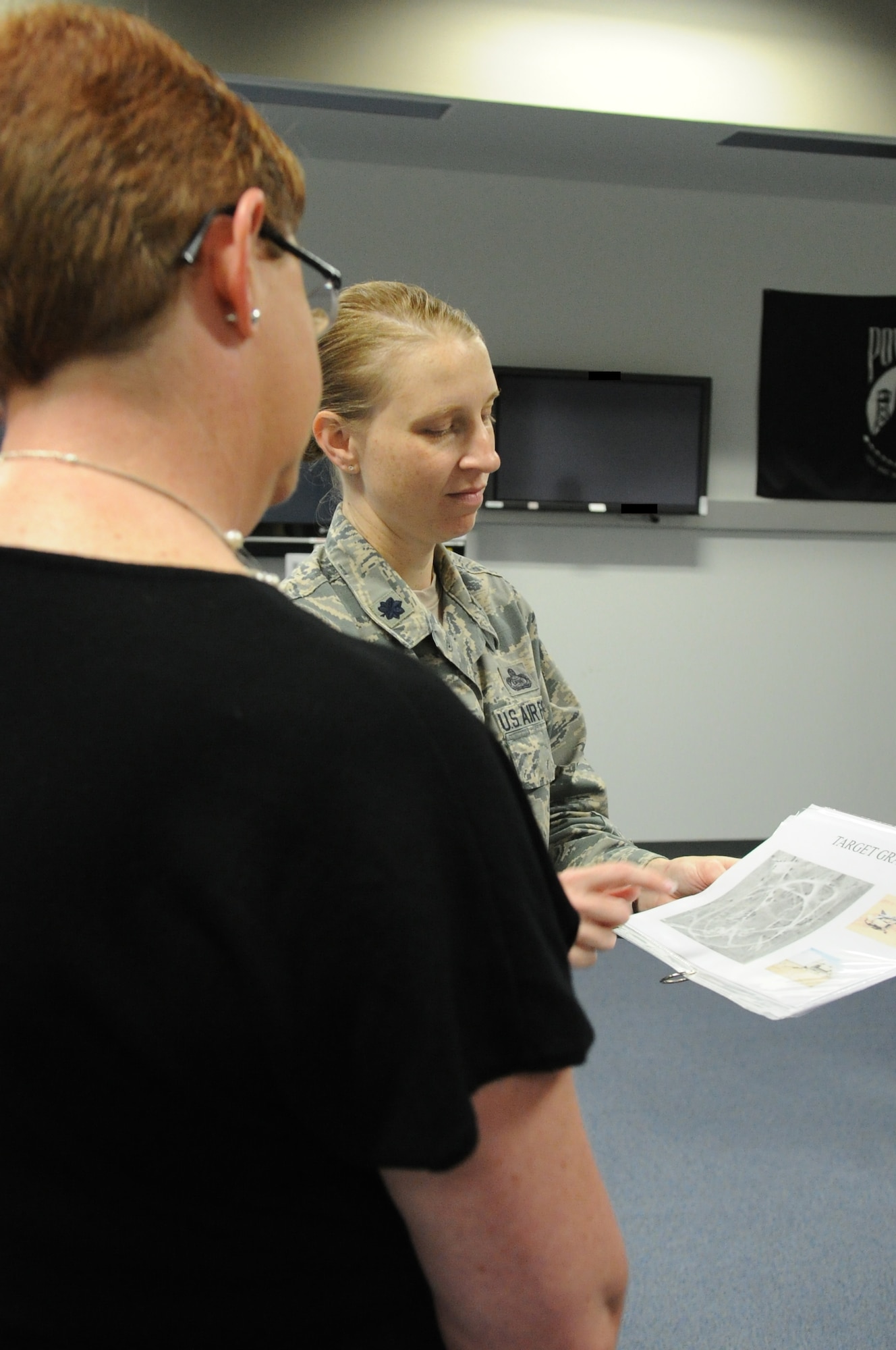 GOODFELLOW AIR FORCE BASE, Texas -- Lt. Col. Caeli A. Hull, 315th Training Squadron Commander, assists Tennie Good, open house attendee, with a training exercise during the Joint Intelligence Technical Training Facility’s open house here March 29. The open house included 10 stations that offered briefers and interactive demos showing the training capabilities of the JITTF. (U.S. Air Force photo/ Staff Sgt. Laura R. McFarlane)