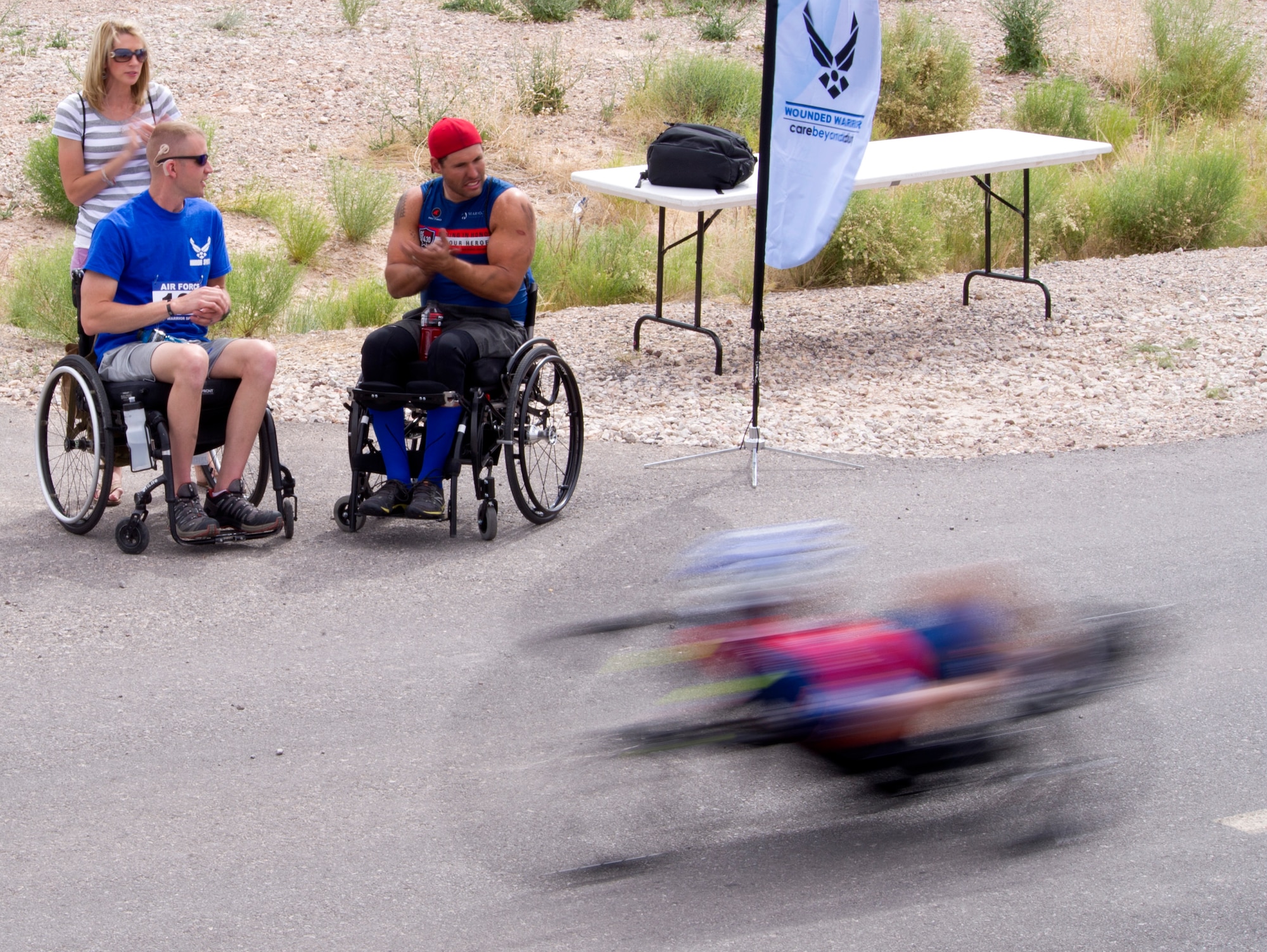 Wounded warriors and staff cheer a fellow participants at cycling competition during the 2014 Wounded Warrior Air Force Trials at Nellis Air Force Base, Las Vegas, Nev., April 9, 2014. Active duty and retired Airmen competed in swimming, basketball, volleyball, track and filed events, archery and shooting competitions.(U.S. Air Force photo by Airman 1st Class Christian Clausen)