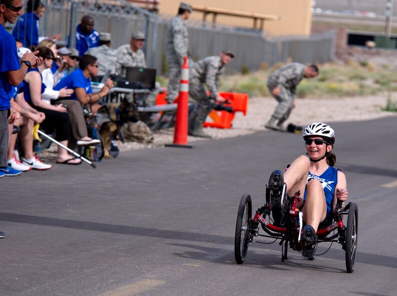 A wounded warrior cycles down the home stretch in the cycling competition during the 2014 Wounded Warrior Air Force Trials at Nellis Air Force Base, Las Vegas, Nev., April 9, 2014. Active duty and retired Airmen competed in swimming, basketball, volleyball, track and filed events, archery and shooting competitions.(U.S. Air Force photo by Airman 1st Class Christian Clausen)