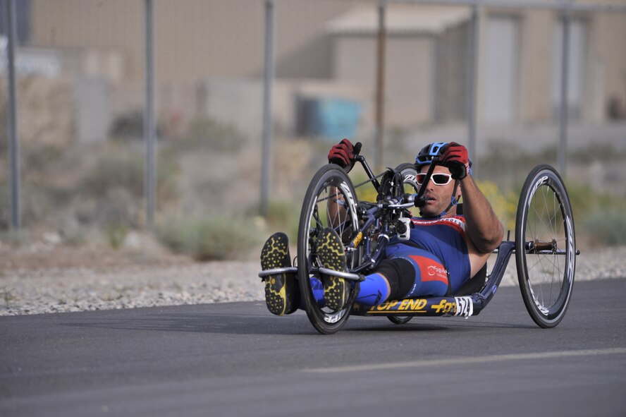 Staff Sgt. Mark Johnson and service dog Bailey wait for the start of the cycling competition during the 2014 Wounded Warrior Air Force Trials at Nellis Air Force Base, Las Vegas, Nev., April 9, 2014. Active duty and retired Airmen competed in swimming, basketball, volleyball, track and filed events, archery and shooting competitions.(U.S. Air Force photo by Airman 1st Class Christian Clausen)