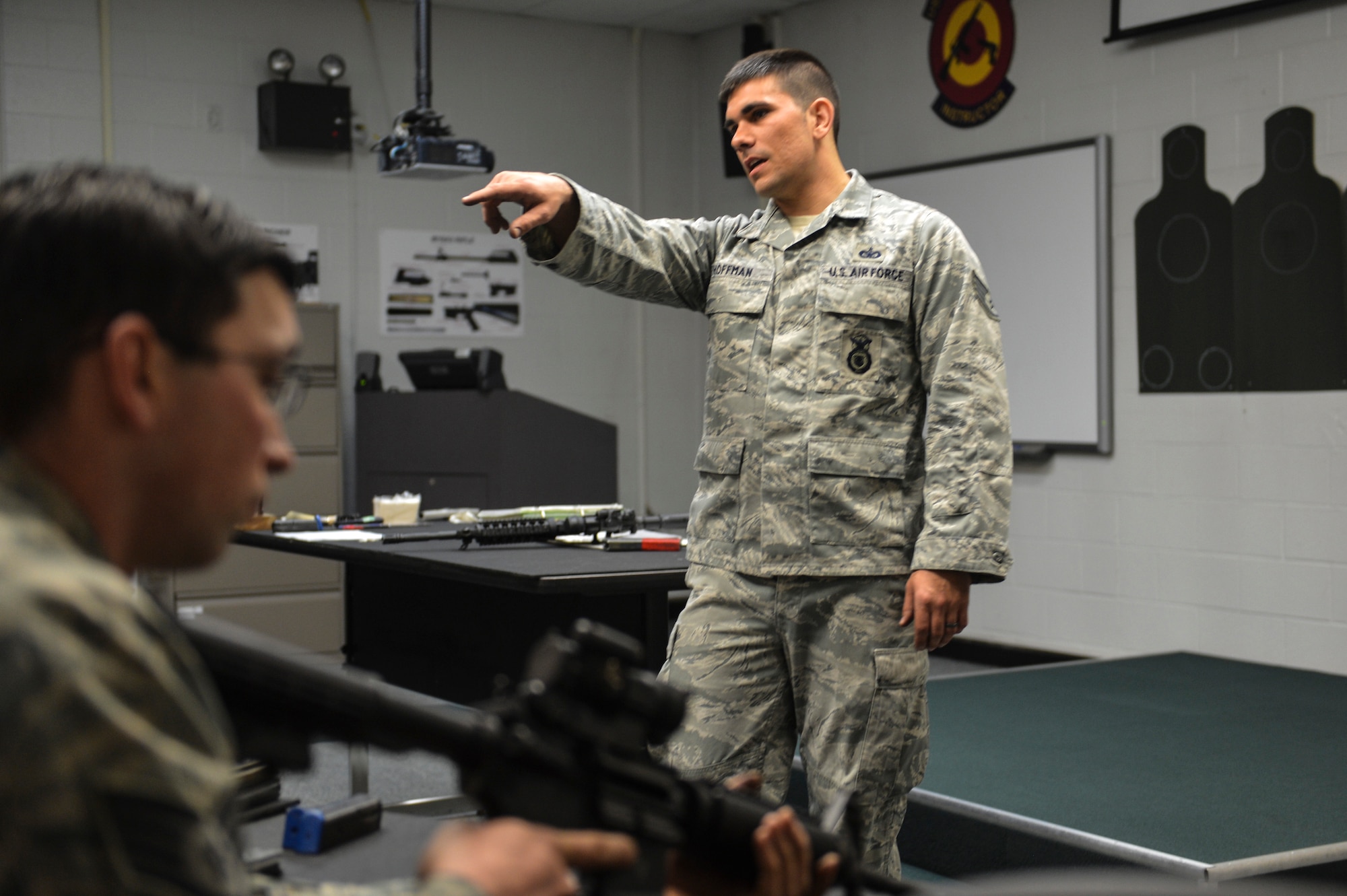 Staff Sgt. Christopher Hoffman, 627th Security Forces Squadron combat arms instructor educates McChord Field Airmen proper technique for reloading the M-4 carbine rifle, April 9, 2014 at Joint Base Lewis-McChord, Wash. In the classroom, McChord Field Airmen gain in-depth knowledge of the M-4 carbine rifle including safety, inspecting, and cleaning. (U.S. Air Force photo/Staff Sgt. Russ Jackson)