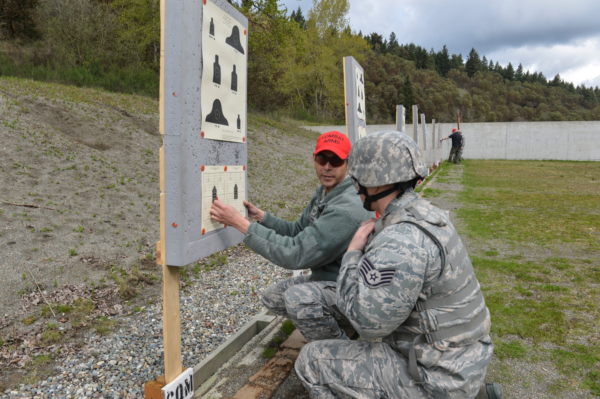 Tech. Sgt. David Buchanan, 446 Security Forces Squadron combat arms instructor, explains zeroing rifle corrections to Staff Sgt. James Horne, 62nd Maintenance Squadron crew chief, at Range 108 next to North Fort Lewis, April 9, 2014 at Joint Base Lewis-McChord, Wash. Airmen need to accomplish weapons training and qualification prior to deploying to an area that requires them to carry a weapon. (U.S. Air Force photo/Staff Sgt. Russ Jackson)