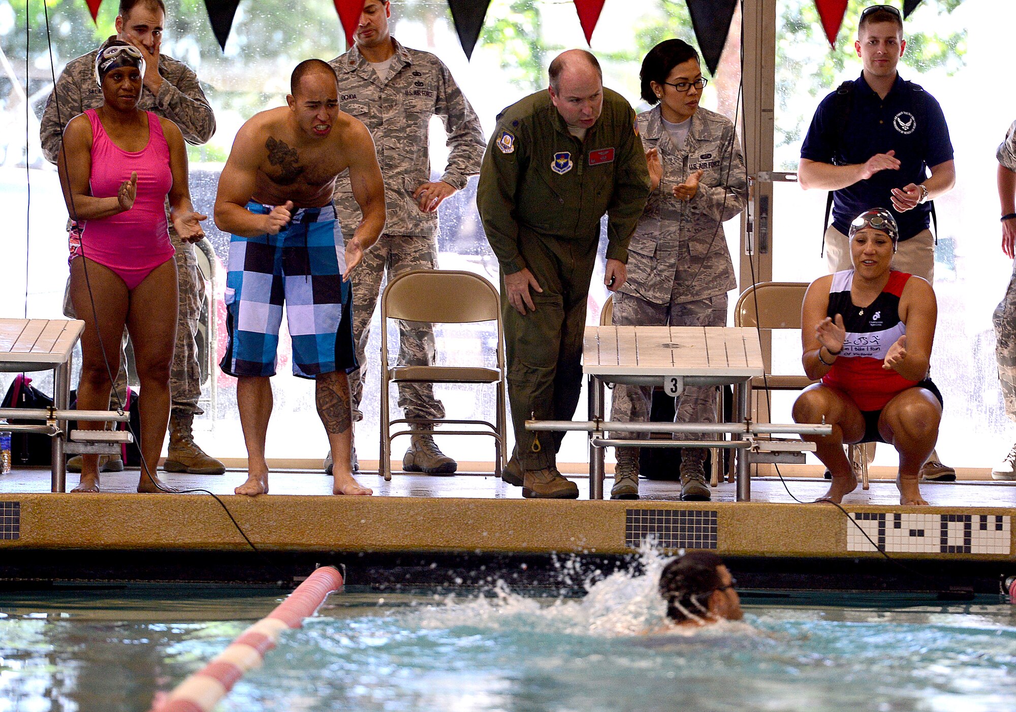Airmen and fellow wounded warriors cheer on (Ret.) Staff Sgt. Daniel Crane, as he finishes the men's  50 meter race during the Wounded Warrior Team Trials April 7, 2014. Crane finished in first place for the upper body impairment swimming trial. (U.S. Air Force photo by Staff Sgt. Nadine Barclay)