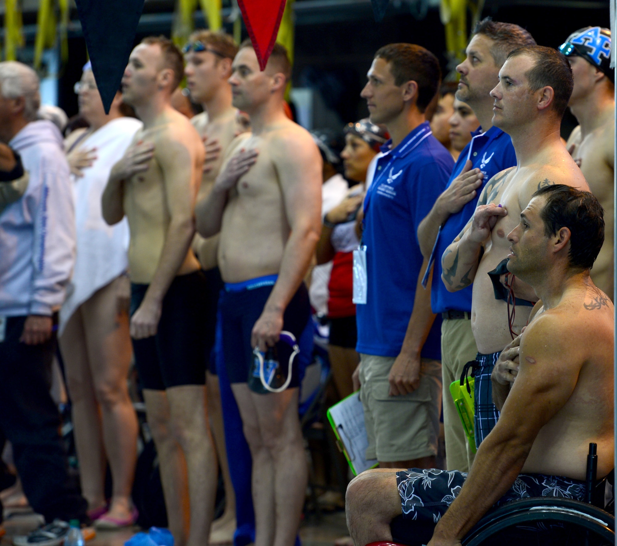Wounded Warriors and staff render respects to the flag during the playing of the national anthem at the Wounded Warrior Team Trials April 7, 2014. During the competition the wounded warriors competed in various swimming trials.(U.S. Air Force photo by Staff Sgt. Nadine Barclay)