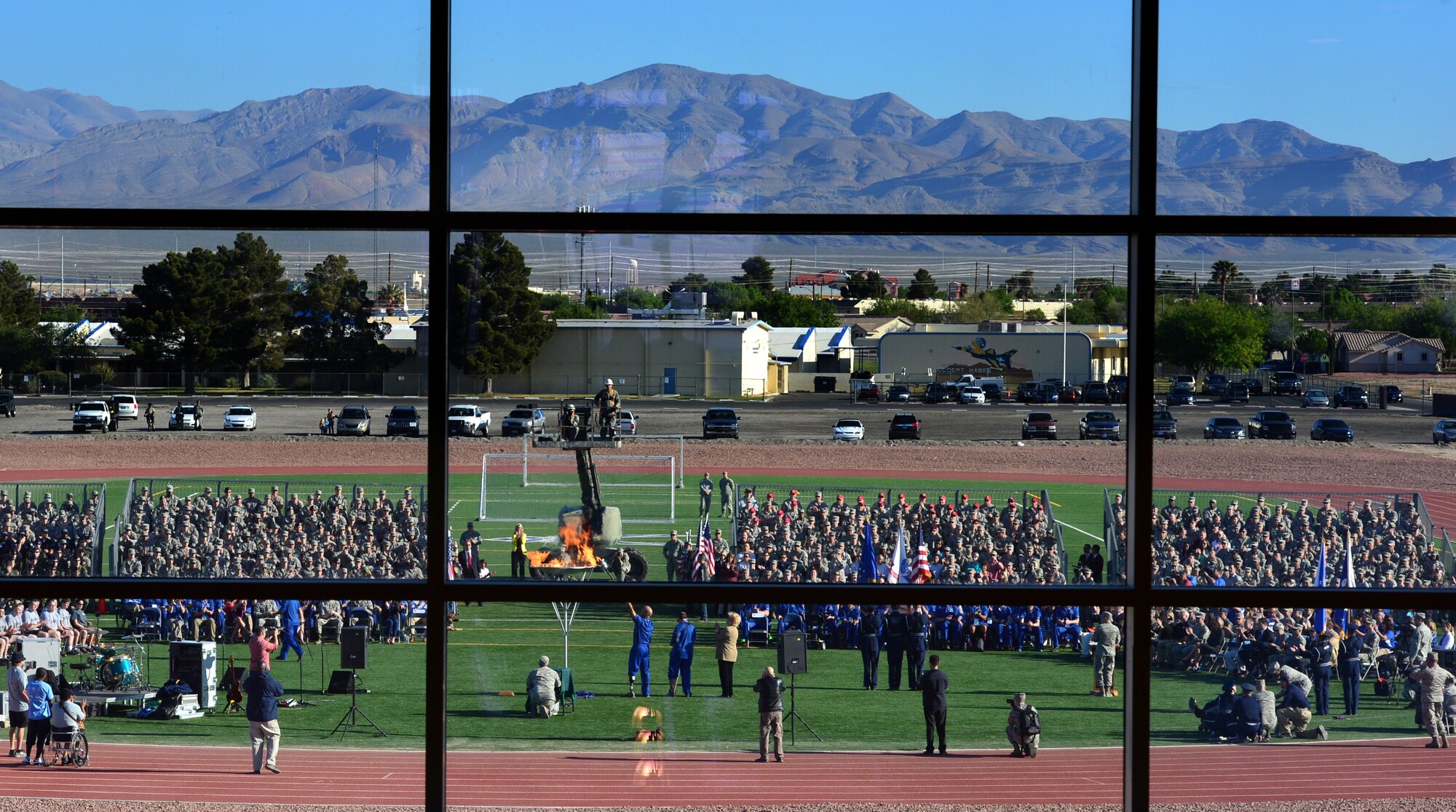 Airmen watch as the torch is lit during the opening ceremony of the 2014 Wounded Warrior Air Force Team Trials at Nellis Air Force Base, Nev., April 7, 2014. Active duty and retired  Airmen competed in swimming, basketball, volleyball, track and filed events, cycling, archery and shooting competitions. (U.S. Air Force photo by Staff Sgt. Nadine Barclay)