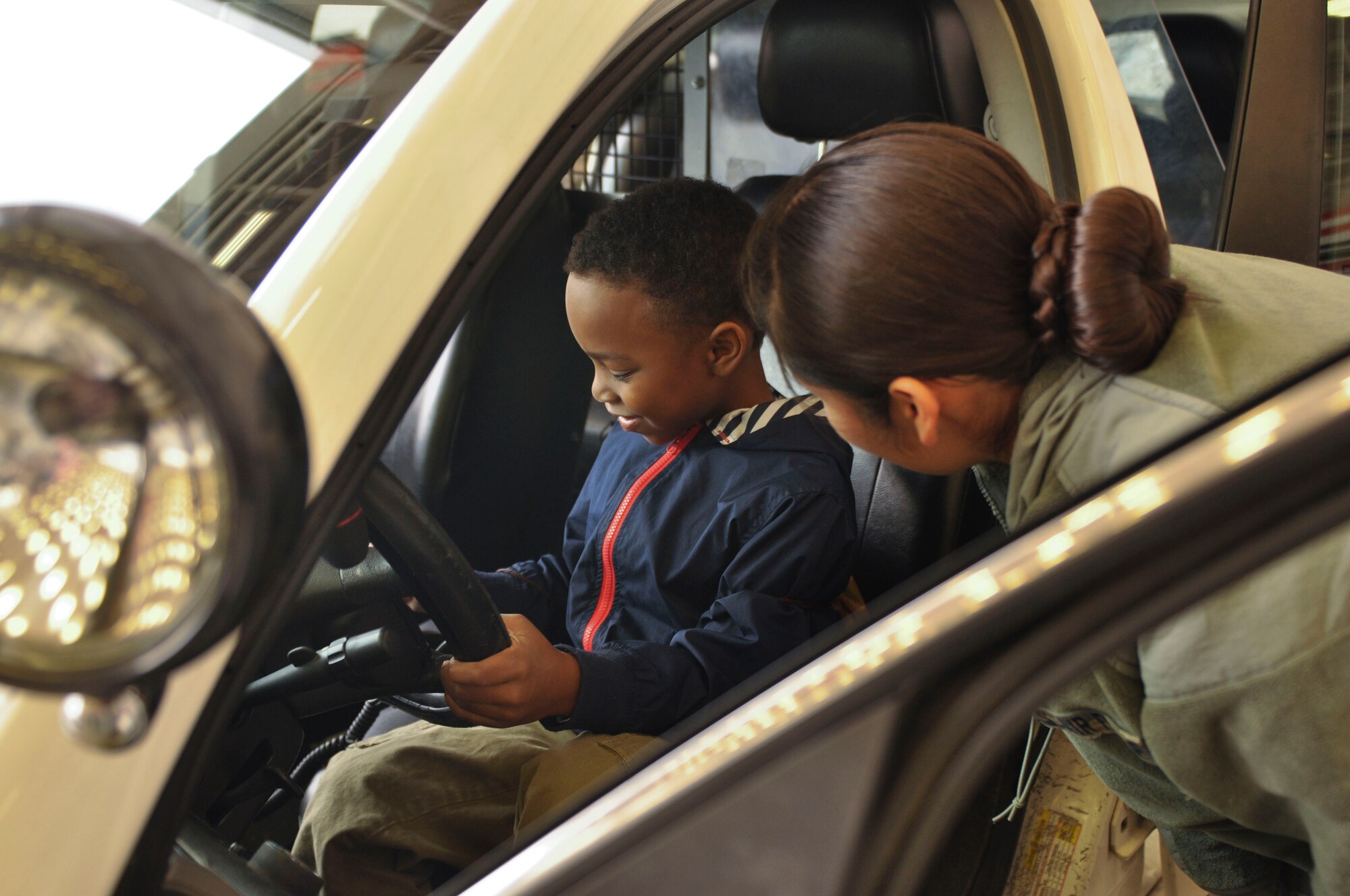 Adam, 7, explores the functions of a 19th Security Forces Squadron car April 5 during the Kids Understanding Deployment Operations event at Little Rock Air Force Base, Ark. The 19th Security Forces Squadron also had a weapons display, combative demonstration and working dog demonstrations. (U.S. Air Force photo by Senior Airman Regina Agoha)