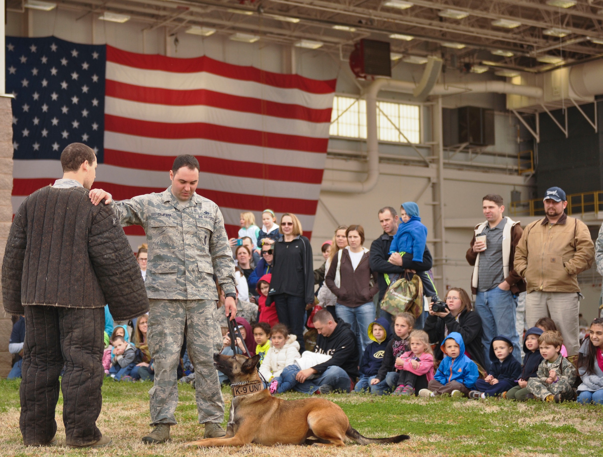 Staff Sgt. James Campana, a 19th Security Forces Sqaudron military dog handler, demonstrates how a military working dog protects its handler when a threat is near April 5 during the Kids Understanding Deployment Operations event at Little Rock Air Force Base, Ark. It takes 120 days to completely train a military working dog. (U.S. Air Force photo by Senior Airman Regina Agoha)