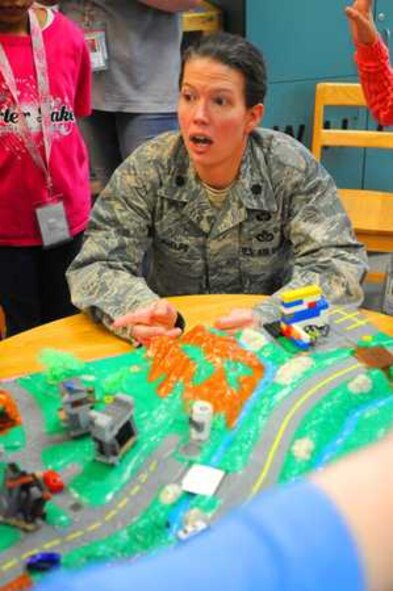 Lt. Col. Jennifer Phelps explains water run-off effects to kids at McChord Youth Center. (Northwest Guardian photo by Jake Dorsey) 