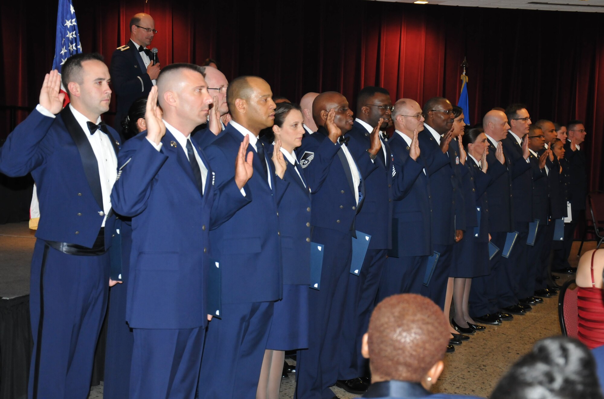 Col. Raymond A. Kozak (background left), 512th Airlift Wing commander, administers the senior noncommissioned officer oath to 32 reservists during an induction ceremony April 5, 2014, at the Delaware Technical Community College Conference Center, Dover, Del. The families, friends and Air Force colleagues of this year's inductees gathered in attendance to celebrate the annual event. (U.S. Air Force photo/Senior Airman Joe Yanik)