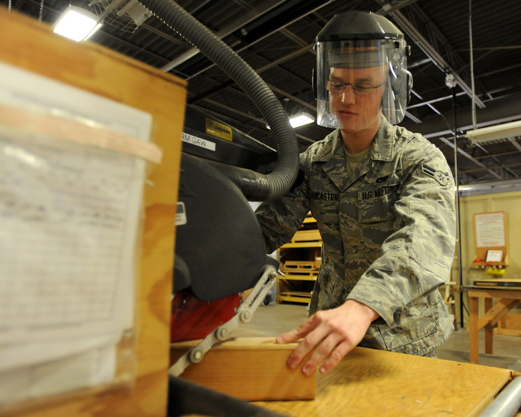 Airman 1st Class Carter Lancaster, 319th Logistics Readiness Squadron traffic management apprentice, cuts wood to be used in shipping material in the LRS packaging warehouse on Grand Forks Air Force Base, N.D., on April 3, 2014. Lancaster was named Warrior of the Week for the first week of April. (U.S. Air Force photo/Senior Airman Zachiah Roberson)
