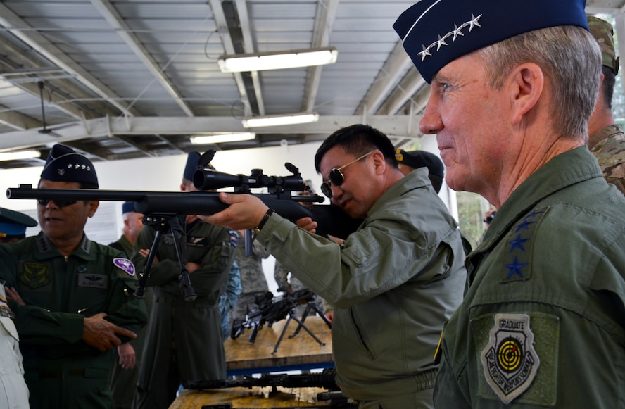 Col. Ganhkhuyag Batkhurel, the commander of Air and Air Defense Forces of the Armed Forces of Mongolia, takes aim while Gen. Herbert Carlisle, Pacific Air Forces commander, looks on during a visit to the Ground Combat Training Squadron at Eglin Air Force Base, Fla., April 2. The Pacific Air Chiefs received a demonstration of various combative skills and tactics. Ranking Air Chiefs from 12 different countries in the Asian Pacific Region visited the base as part of the Pacific Air Chief's Symposium, one of the Air Force's multilateral engagement opportunities used to build relationships with Pacific countries and enhance theater security cooperation.  (U.S. Air Force photo/Linda Phillips)
