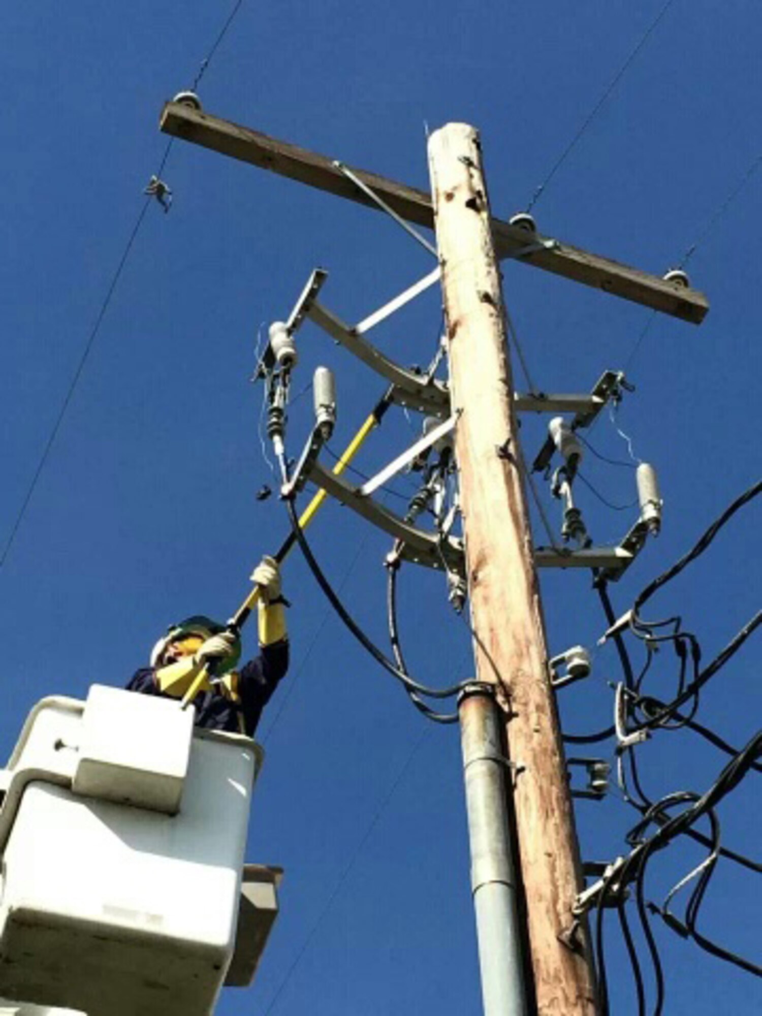 Senior Airman Josue Morataya, 2nd Civil Engineer Squadron electrical systems journeyman, connects hot line clamps to a high voltage line on Barksdale Air Force Base, La., April 4, 2014. The high voltage line contains a current of 12,470 volts and connects to a transformer that converts high voltage electricity to a usable voltage for several buildings. (Courtesy photo)