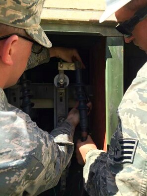 Airman 1st Class James Scott, 2nd Civil Engineer Squadron electrical systems apprentice, and Staff Sgt. Jose Arriaga, 2nd CES electrical systems journeyman, install cable terminations in a transformer on Barksdale Air Force Base, April 4, 2014.  The cable installation was part of a utility pipe repair. (Courtesy photo)