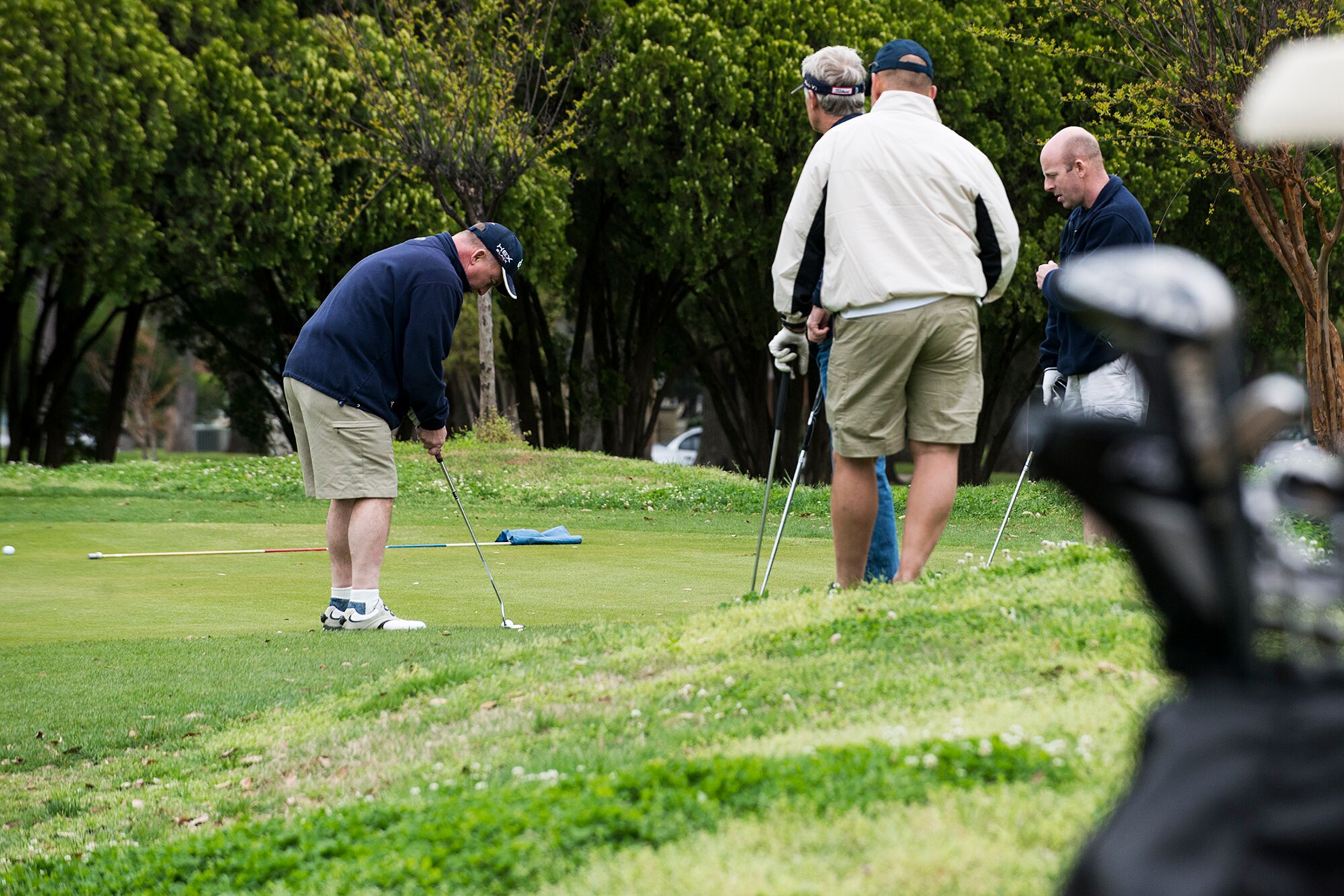 A golfer focuses on his putt before attempting a shot during the 307th Bomb Wing Commander's Cup golf tournament, April 5, 2014, Barksdale Air Force Base, La. The tournament coincides with Family Day, which is held annually to inspire camaraderie and give military members to include their families. (U.S. Air Force photo by Master Sgt. Greg Steele/Released)