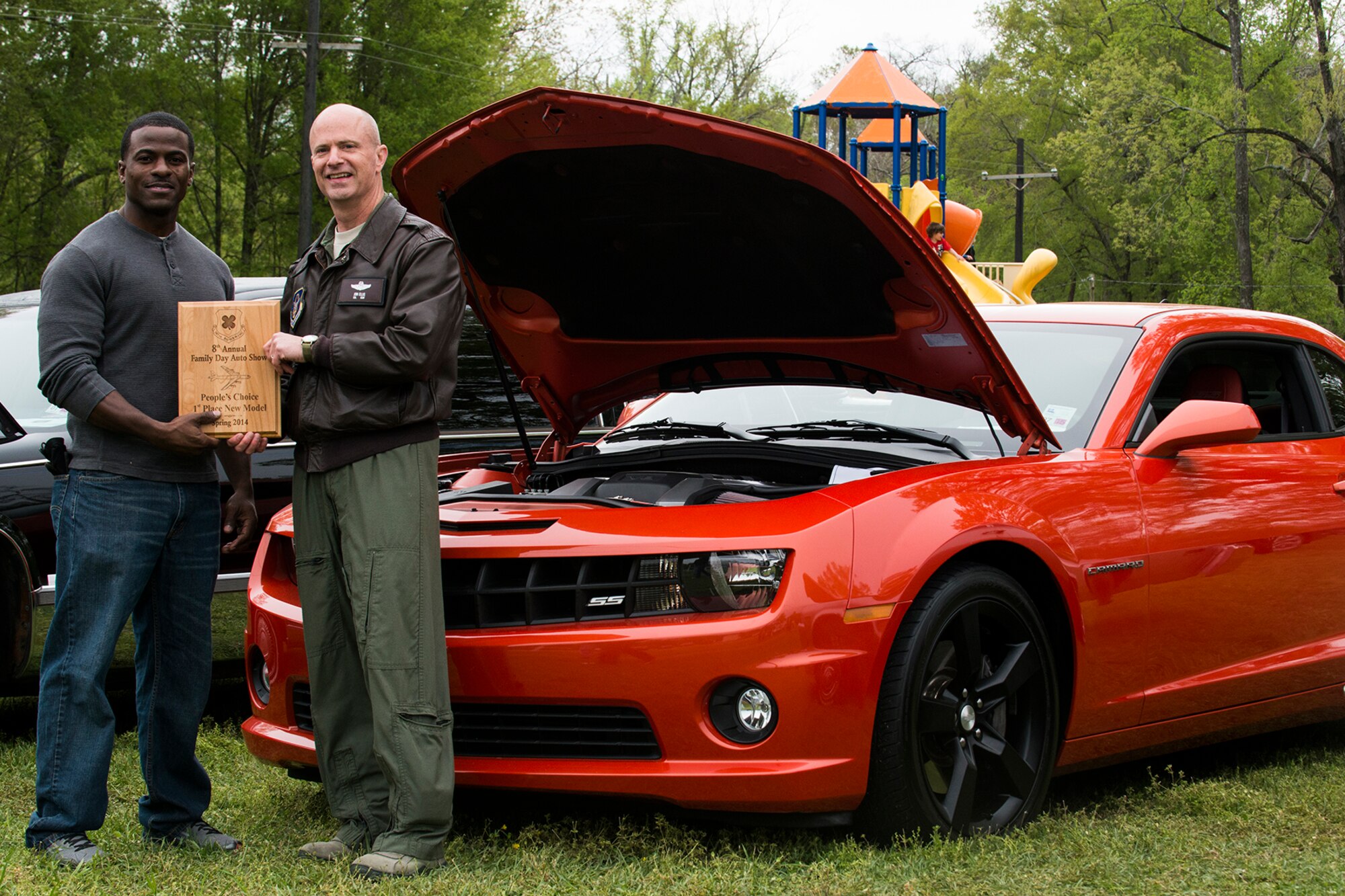 U.S. Air Force Col. Jonathan Ellis, 307th Bomb Wing commander, presents a People's Choice award to Tech. Sgt. Keyne Moseley during Family Day, April 5, 2014, Barksdale Air Force Base, La. Winners of the Car Show are decided by votes submitted by attendees of Family Day. (U.S. Air Force photo by Master Sgt. Greg Steele/Released)