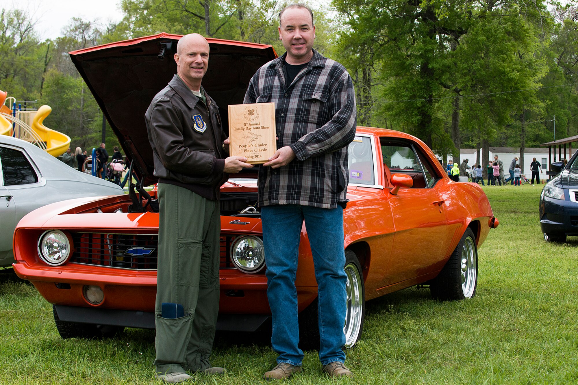 U.S. Air Force Col. Jonathan Ellis, 307th Bomb Wing commander, presents a People's Choice award to Tech. Sgt. Stephen Sorge during Family Day, April 5, 2014, Barksdale Air Force Base, La. Winners of the Car Show are decided by votes submitted by attendees of Family Day. (U.S. Air Force photo by Master Sgt. Greg Steele/Released)