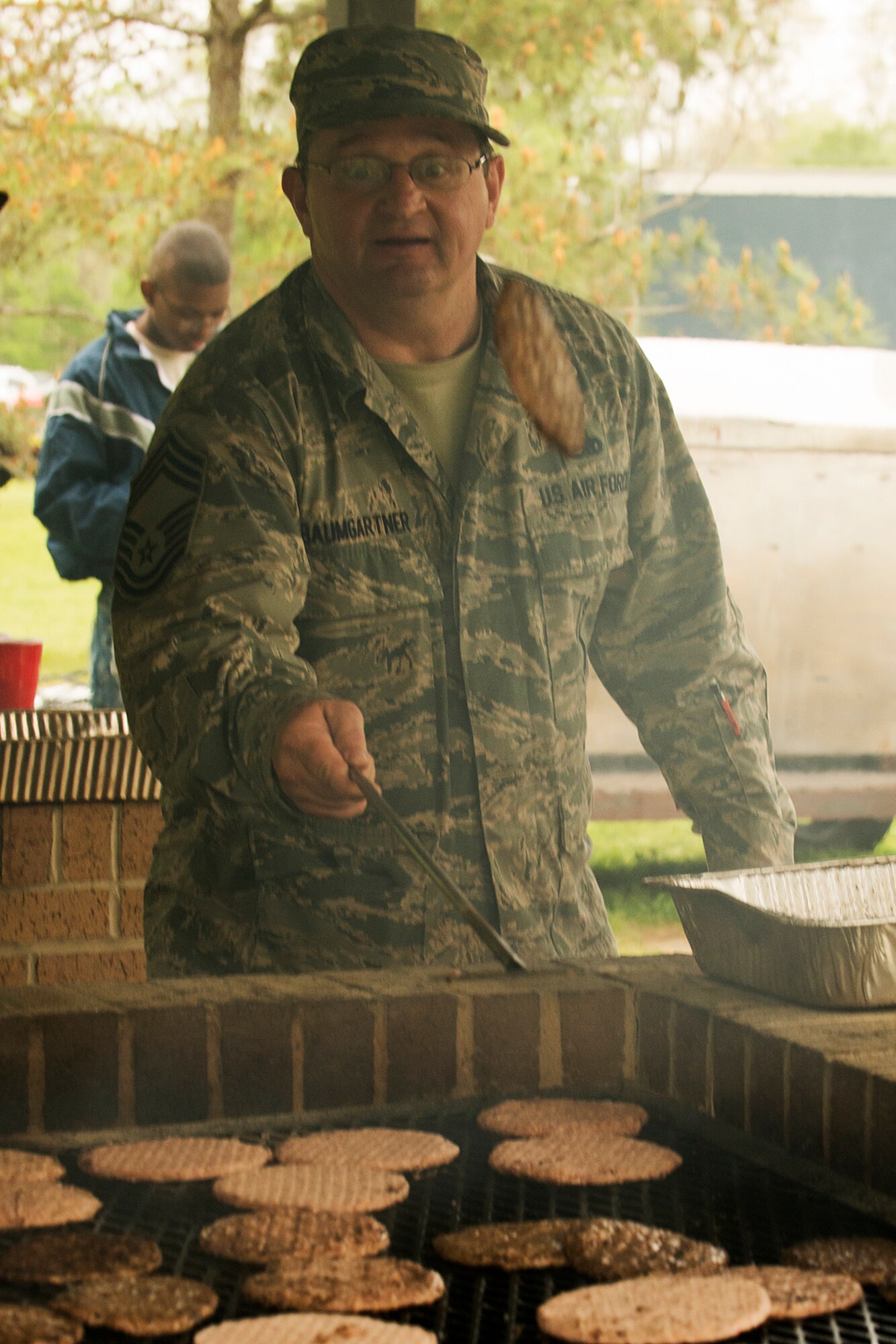 U.S. Air Force Chief Master Sgt. Douglas Baumgartner flips a burger during the 307th Bomb Wing Family Day, April 5, 2014, Barksdale Air Force Base, La. Family Day is an annual event which gives Airmen an opportunity to take a timeout from their duties to build camaraderie and have fun. (U.S. Air Force photo by Master Sgt. Greg Steele/Released)