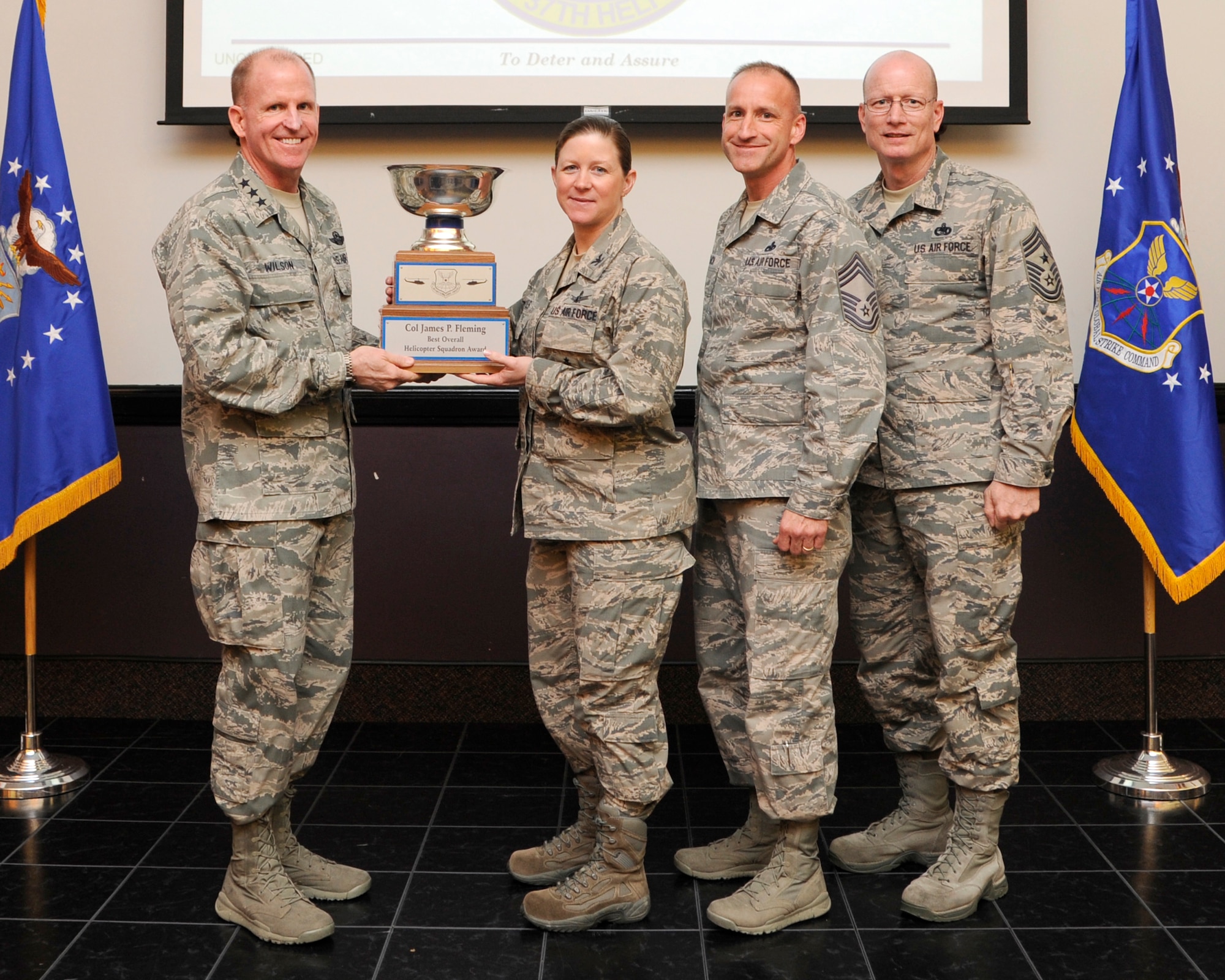 Lt. Gen. Stephen Wilson, Air Force Global Strike Command commander presents the Col. James P. Fleming Award for Best Overall Helicopter Squadron to Col. Tracey Hayes, 90th Missile Wing commander during a ceremony at Barksdale Air Force Base, April 9. The award is presented annually to the wing recognized as the best in their field. (U.S. Air Force photo/Senior Airman Joseph A. Pagán Jr.)