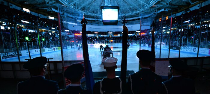 Servicemen from the Joint Base Charleston Honor Guard, prepare to take the ice and present the colors during a South Carolina Stingrays hockey game March 22, 2014, at the North Charleston Coliseum. (US Air Force Photo/Senior Airman Daniel Hughes)