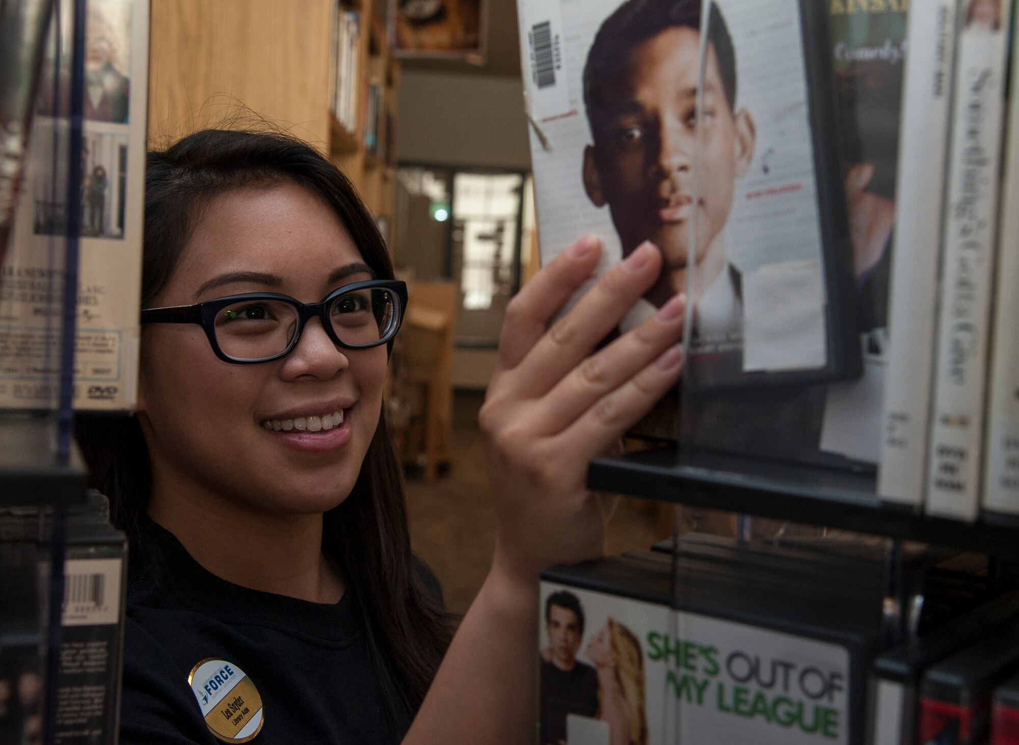 Lea Snyder, 47th Force Support Squadron library aid, puts a DVD back on a shelf in the library’s video section on Laughlin Air Force Base, Texas, April 4, 2014. The base’s library provides a variety of services for the base population including book and video rentals, audiobooks, children programs, language development and more. (U.S. Air Force photo/Senior Airman Nathan Maysonet/Released)