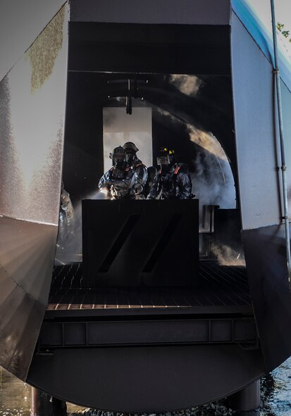 Fire emergency services Airmen from the 23d Civil Engineer Squadron hose down the inside of a mock C-130 aircraft at the fire department training pit on Moody Air Force Base, Ga., April 9, 2014. The training is completed quarterly to ensure Airmen remain proficient on their job duties. (U.S. Air Force photo by Airman 1st Class Alexis Millican/Released)