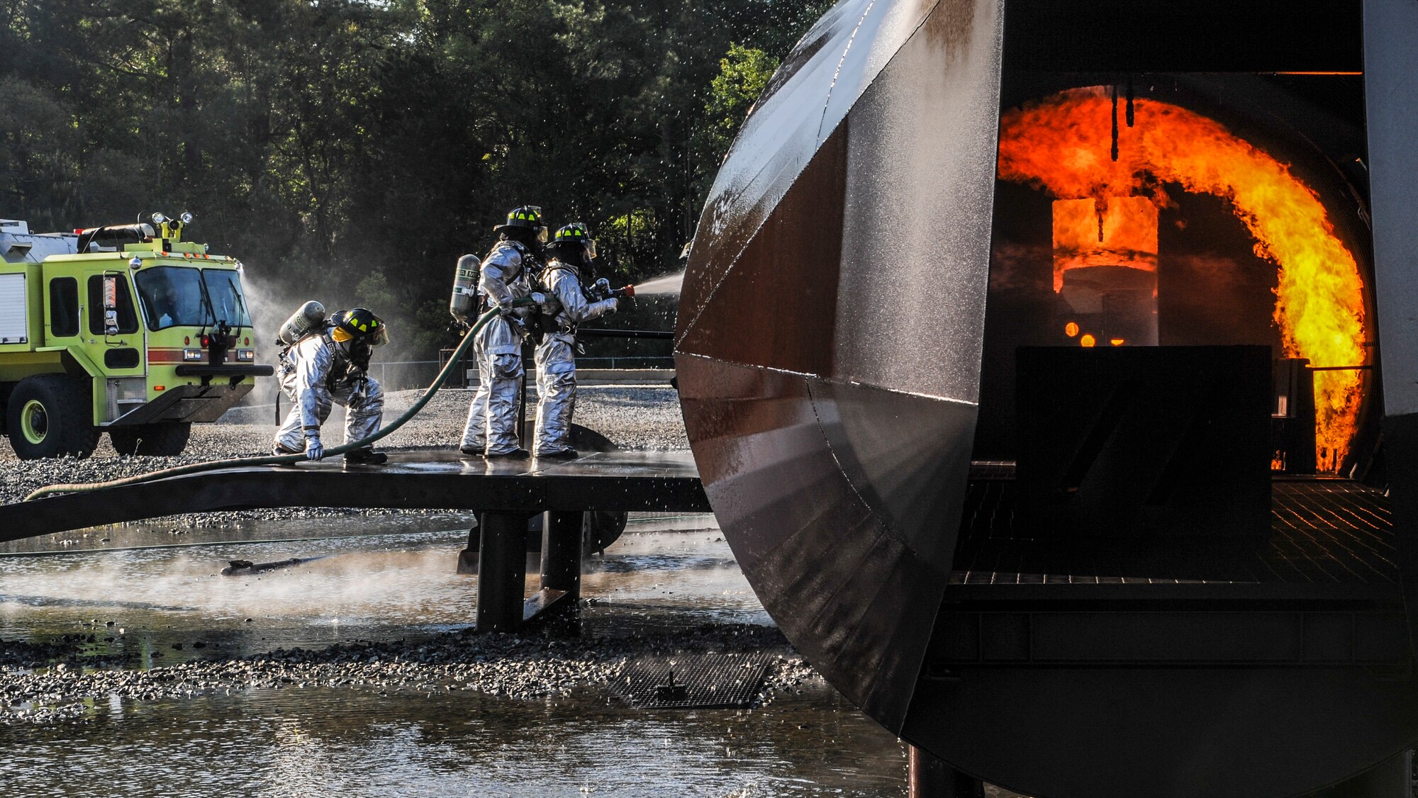 Fire emergency services Airmen from the 23d Civil Engineer Squadron fight a controlled fire at the fire department training pit on Moody Air Force Base, Ga., April 9, 2014. There were 12 ignition points on the outside of the training structure and five ignition points on the inside. (U.S. Air Force photo by Airman 1st Class Alexis Millican/Released)