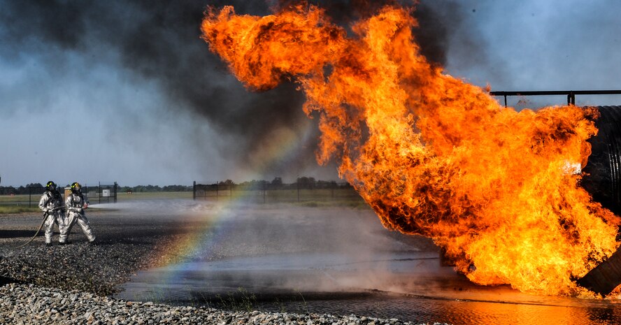 Fire emergency services Airmen from the 23d Civil Engineer Squadron spray water on a fire at the fire department training pit on Moody Air Force Base, Ga., April 9, 2014. The fire emergency services flight regularly conducts live fire training to remain proficient at their job. (U.S. Air Force photo by Airman 1st Class Alexis Millican/Released)