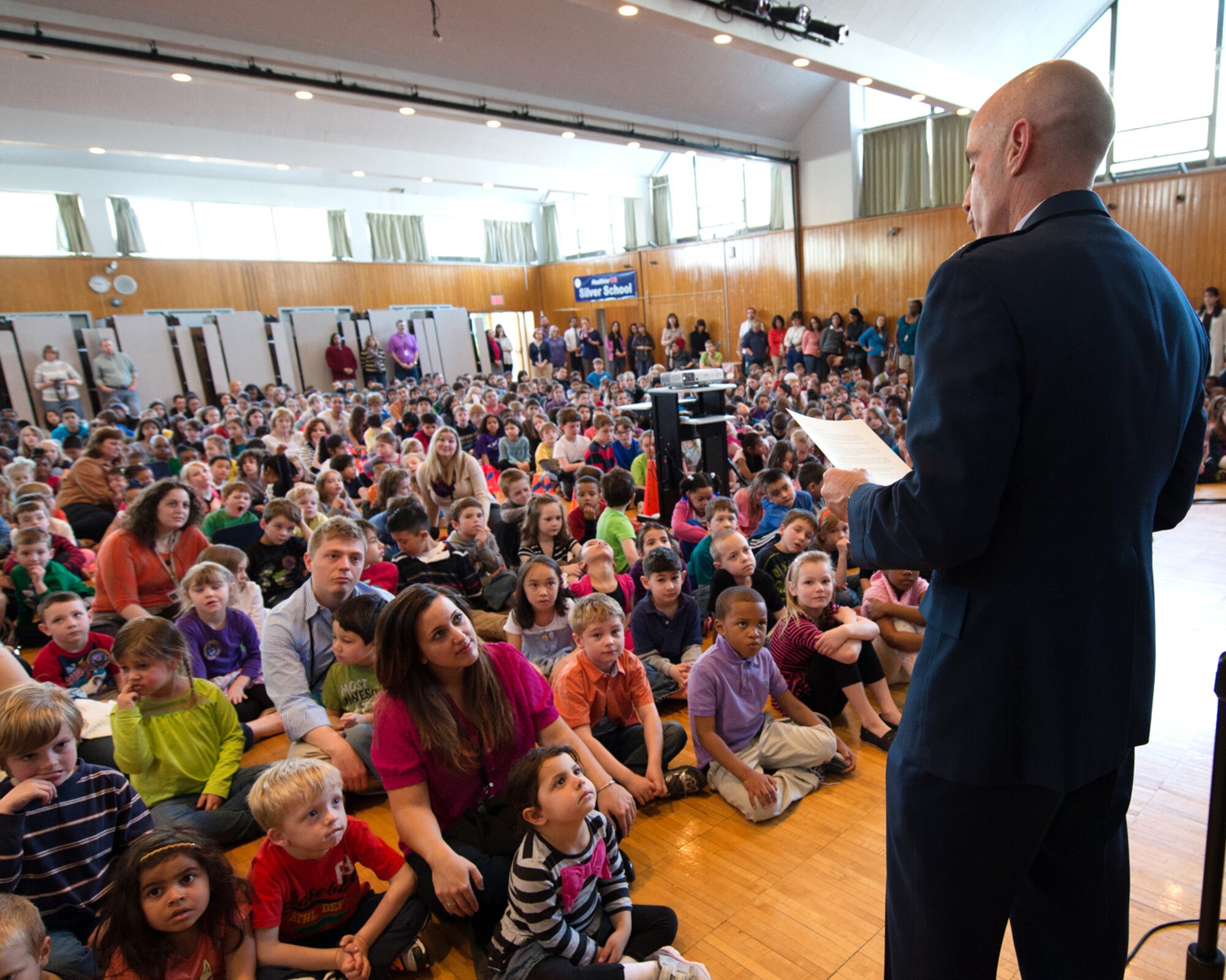 HANSCOM AIR FORCE BASE, Mass.  – Col. Lester A. Weilacher, 66th Air Base Group commander, reads a proclamation he had just signed to students assembled in the Hanscom Middle School all-purpose room April 9 as part of a program highlighting the Month of the Military Child. Each year the Hanscom schools hold the Month of the Military Child assembly to honor military students. During his remarks, Weilacher expressed his appreciation to children for their continued support to their families, peers, while experiencing their own unique challenges as a military child. (U.S. Air Force photo by Mark Herlihy)