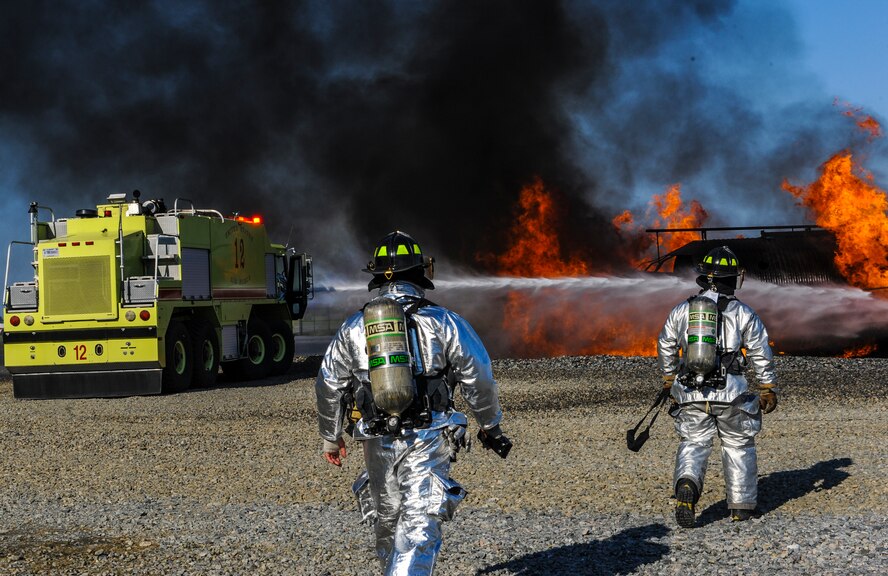 Fire emergency services Airmen from the 23d Civil Engineer Squadron respond to a fire at the fire department training pit on Moody Air Force Base, Ga., April 9, 2014. The fire simulated a burning C-130 and tested the  unit on their readiness and response. (U.S. Air Force photo by Airman 1st Class Alexis Millican/Released)