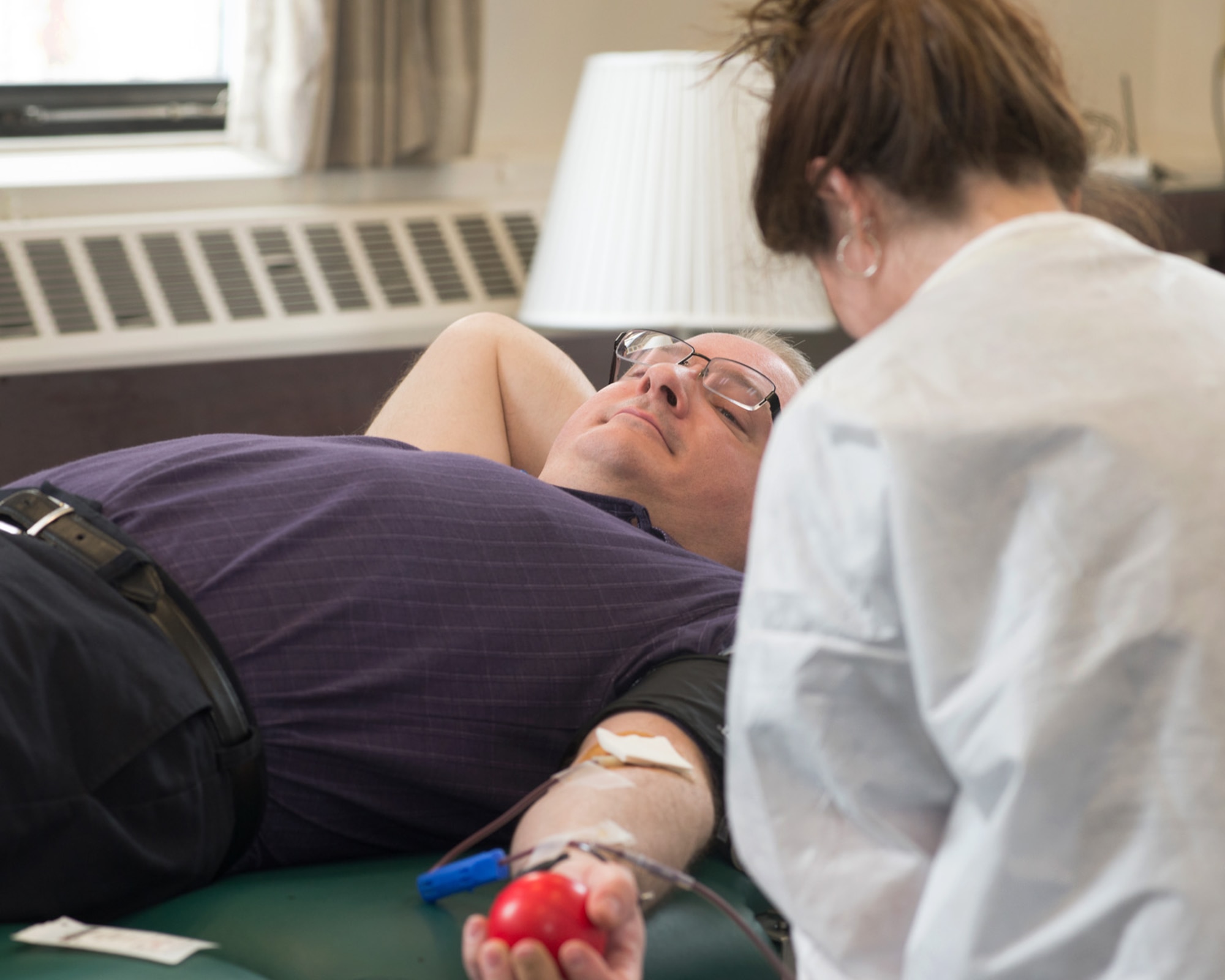 HANSCOM AIR FORCE BASE, Mass. – Nancy Hawes, right, a Red Cross staff member, draws blood from Eric Delage at the Hanscom Conference Center during a Red Cross Blood Drive, April 8. For more information on donating blood through the Red Cross, visit redcross.org/donate/give. (U.S. Air Force photo by Mark Herlihy)