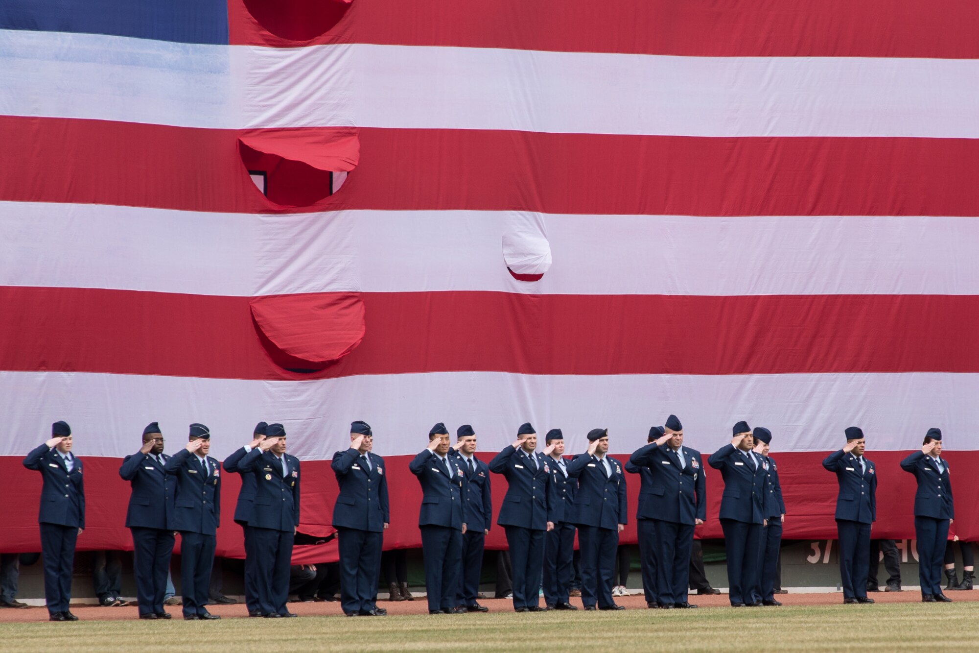 BOSTON – Airmen from Hanscom Air Force Base salute during the playing of the national anthem at Fenway Park for Boston Red Sox opening day festivities April 4. After the first pitch, the Airmen gathered the American flag from the Green Monster and carried it off the field. (U.S. Air Force photo by Mark Herlihy)