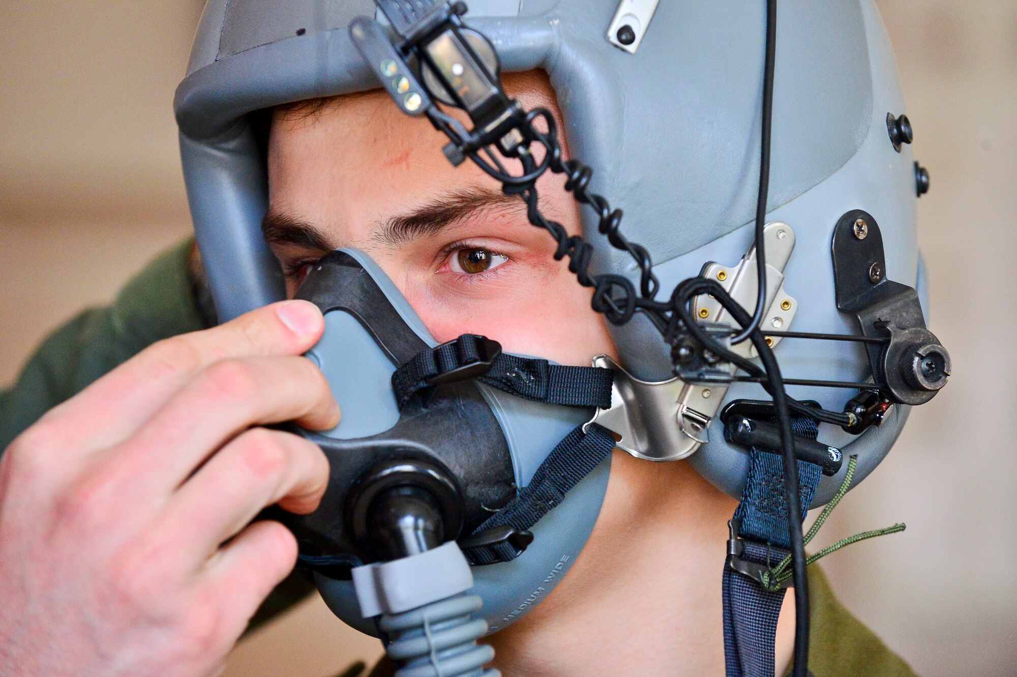 A Gen. Dr. Romana Abrahama Secondary School student receives instruction from a U.S. Air Force C-130J Super Hercules pilot on the use and importance of a flight helmet and oxygen mask, in Wrzesnia, Poland, April 4, 2014 during the U.S. Aviation Detachment 14-2 rotation. The students are equivalent to U.S. Air Force Junior Reserve Officer Training Corps.  (U.S. Air Force photo/Tech. Sgt. Daylena S. Ricks)