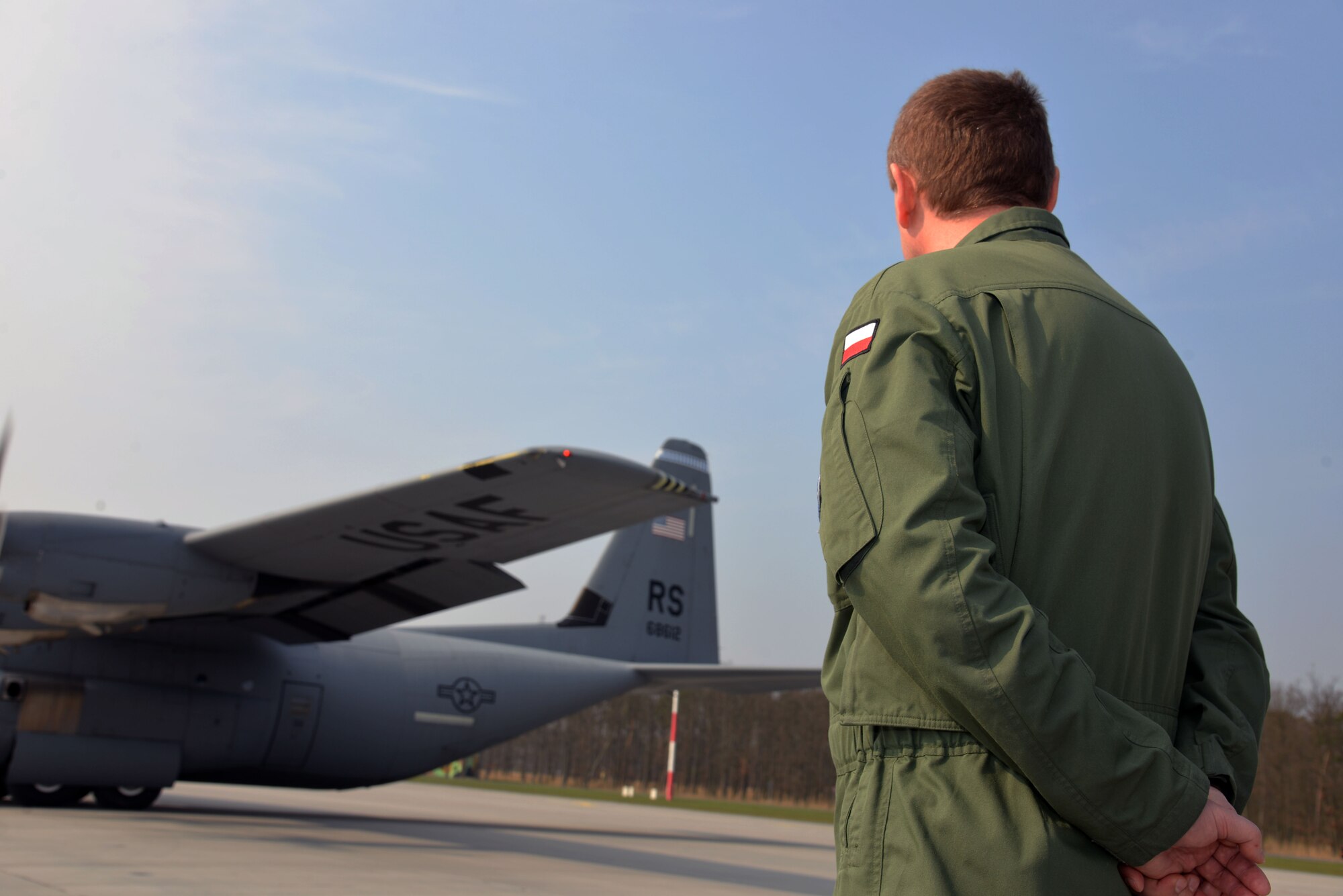 Polish air force Col. Miroslaw Lusiarczyk, 33rd Air Base commander, watches as a U.S.C-130J Super Hercules prepares for take-off at Powidz Air Base, Poland, April 3, 2014. The Polish armed forces and U.S personnel train together at the U.S. Aviation Detachment to build partnership capacity with NATO allies for real-world scenarios until April 12. There are two more Av-Det training rotations in Poland scheduled this fiscal year. (U.S. Air Force photo by 2nd Lt. Katrina Cheesman/Released)