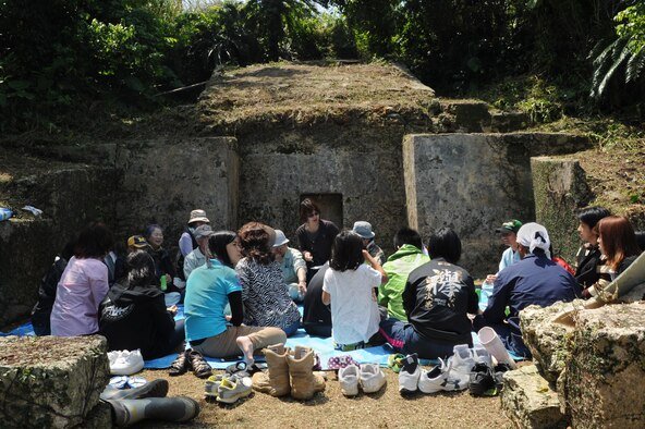 Local citizens gather around their family tomb after praying in observance of Shimi in the Munitions Storage Area on Kadena Air Base, Japan, April 6, 2014. During Shimi, one of the only times locals can visit tombs located in the restricted area, Okinawans clear overgrown plants from the area surrounding their tomb before gathering extended family members to pray, eat and enjoy each other’s company.  About 100 Airmen volunteered to escort more than 400 visiting locals this year.  (U.S. Air Force photo by Airman 1st Class Zade C. Vadnais)