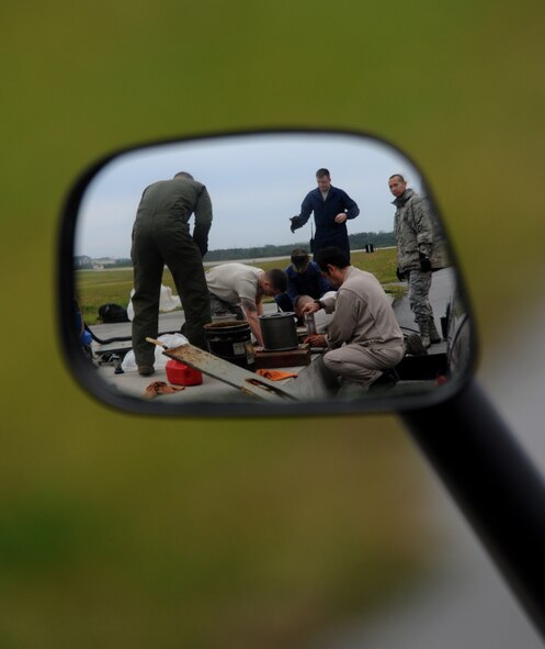 Members from the 18th Civil Engineer Squadron work to remove and clean sheave rollers prior to reinstalling a BAK-12 Aircraft Arresting System on the flightline of Kadena Air Base, Japan, April 7, 2014. The BAK-12 Aircraft Arresting System uses nylon tape that absorbs the energy when the tail hook of an aircraft engages the barrier safely helping to stop the aircraft during its landing. (U.S. Air Force photo by Airman 1st Class Keith James)