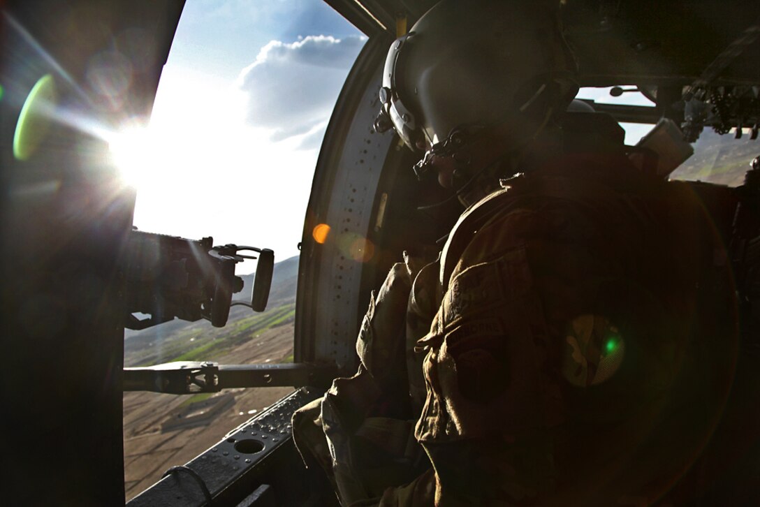 A UH-60 Black Hawk helicopter door gunner provides security while flying over Paktika province, Afghanistan, March 31, 2014.