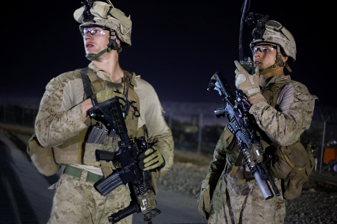 U.S. Marine Corps Cpl. Jordan Kozyarski and U.S. Marine Corps Lance Cpl. Jaquaye Garner provide security at an intersection during a quick reaction force drill on Camp Leatherneck in Helmand province, Afghanistan, March 31, 2014. Kozyarski and Garner, riflemen, are assigned to Alpha Company, 1st Battalion, 9th Marine Regiment.