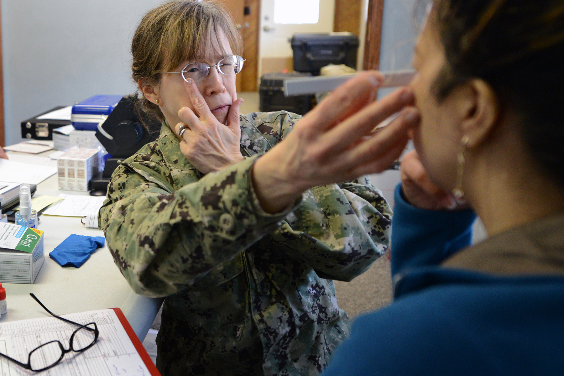 U.S. Navy Cmdr. Patricia Steiner fits a resident patient for eye