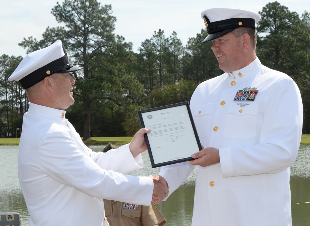 Chief Petty Officer Justin Haugland (right) receives a letter of appreciation from Master Chief Craig Soleim, senior enlisted leader, directorate, Naval Branch Health Clinic, Jacksonville, Fla., Friday, during Haugland’s retirement ceremony held at Covella Pond aboard Marine Corps Logistics Base Albany.