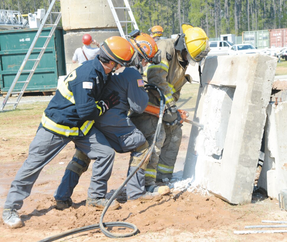 A team works to reach a simulated trapped victim by creating an opening in a slab of concrete during exercise Twisting Thunder 2014 aboard Marine Corps Logistics Base Albany, April 1. This scenario was part of a two-day destructive weather exercise.
