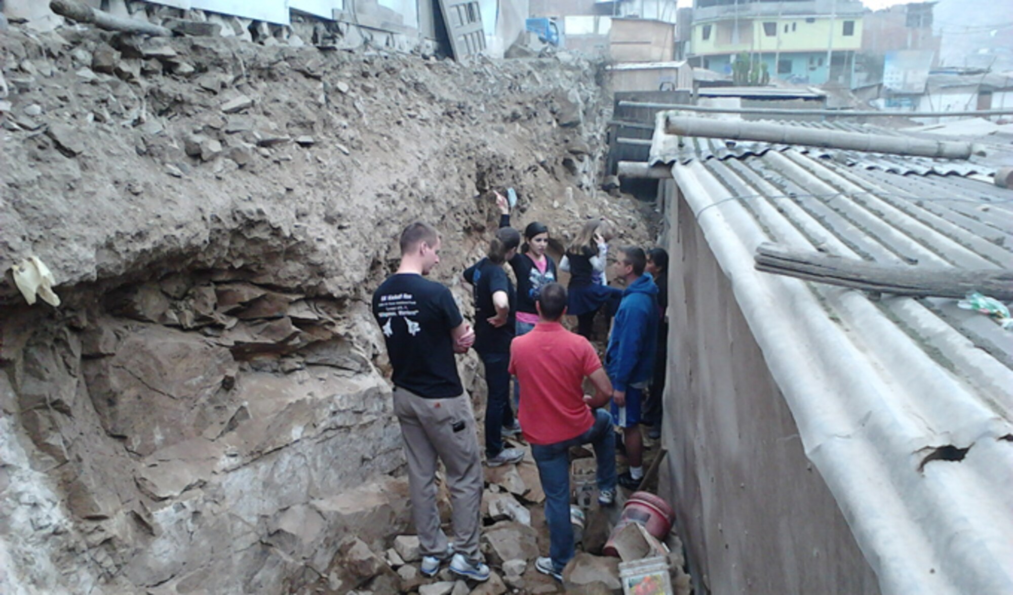 A volunteer group of Air Force and Navy engineers, led by Sarah Rebeca Vieira de Azevedo Ribeiro (middle, facing forward), work to prevent a mudslide threatening a home in an impoverished part of Lima, Peru. Sarah is the fiancée of Maj. Paul Morris, a former international exchange officer who represented the U.S. Air Force as an embedded flight officer with the Peruvian air forces. (Courtesy photo/Maj. Paul Morris)