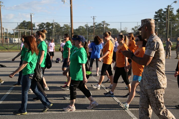 Staff Sgt. Alex Colon-Soto, Headquarters and Headquarters Squadron air traffic controller, teaches the spouses of H&HS and Center for Naval Aviation Technical Training Marine Unit, how to march in the parking lot of AS-211 during an In Their Boots event aboard Marine Corps Air Station New River, N.C., April 5. During the event the spouses got a taste of what Marines do for training. 


