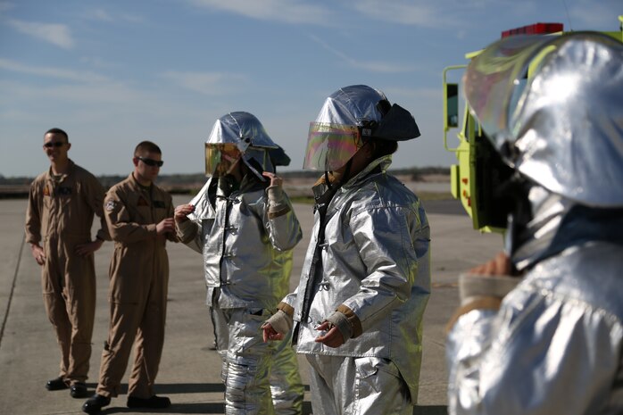 Headquarters and Headquarters Squadron spouses dress in Aircraft Rescue and Fire Fighting protective gear at the flight line aboard Marine Corps Air Station New River, N.C., April 5, as part of an In Their Boots event. During the event, spouses visited a static display of aircraft aboard the air station and viewed ARFF Marines give a demonstration of the speed they have to have during an emergency. 


