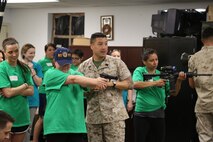 Sgt. Maj. Louis M. Leiva, Headquarters and Headquarters Squadron sergeant major, gives his wife advice while she shoots an M9 Berretta in the indoor simulated marksmanship trainer aboard Marine Corps Air Station New River, N.C., April 5, as part of the In Their Boots event. During the event, spouses got an opportunity to shoot a variety of simulated weapons such as the M4 carbine, the M9 Beretta and the browning .50 caliber machine gun. 


