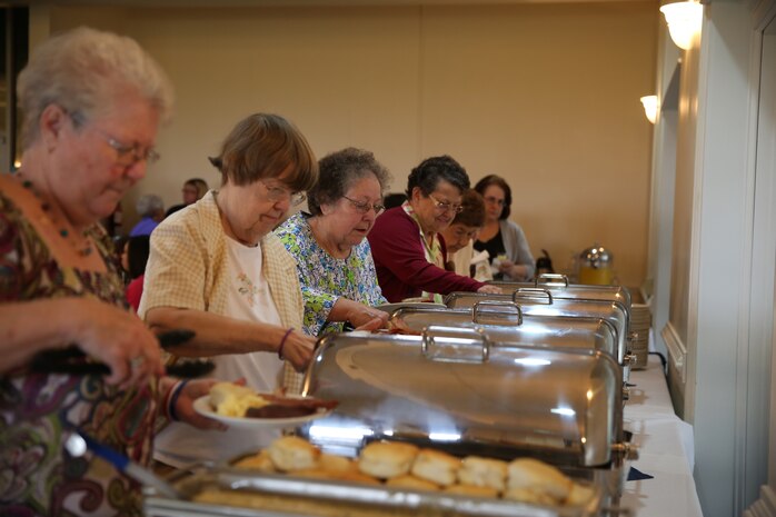 Volunteers from the Navy-Marine Corps Relief Society (NMCRS) get breakfast before the annual NMCRS Volunteer Awards and Recognition Ceremony at the Officers Club aboard Marine Corps Air Station New River, April 7. Volunteers were presented with awards based on how many accumulated volunteer hours they served. (U.S. Marine Corps photo by Lance Cpl. Andy J.  Orozco/Released)


