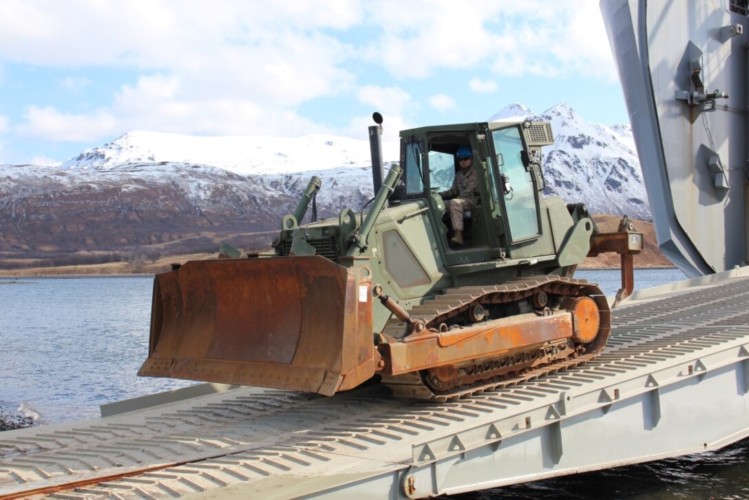 Staff Sgt. William Rueppel, a Marine with Wing Support Squadron (MWSS) 471, Marine Aircraft Group 41, 4th Marine Aircraft Wing, Marine Forces Reserve, drives a Rubber-Tired, Articulated Steering, Multi-Purpose Tractor in Old Harbor, Alaska, April 7, 2014. The engineer equipment will be used during Innovative Readiness Training Old Harbor, a project to extend a remote runway beginning in May running through August. The project will continue work started by the Marine Corps Reserve in 2013 to extend a remote village runway by about 2000 feet. 