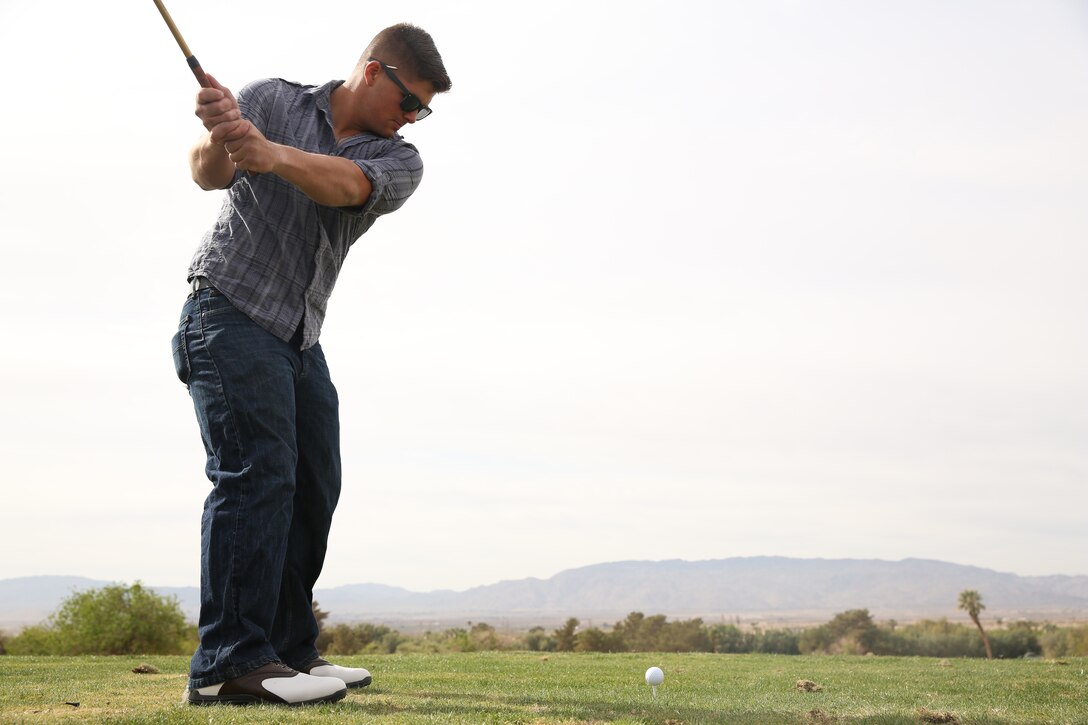 Lance Cpl. Anthony Leandro, ammunition technician, Center Magazine Area, Headquarters Battalion, prepares to strike a ball during a free 18-hole round of golf at Desert Winds Golf Course, April 4, 2014. The Marines were provided clubs, balls and caddies for the game.


