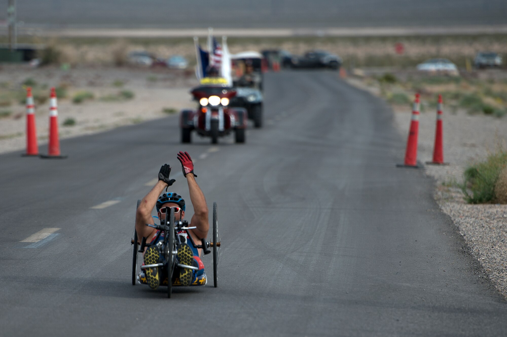 Ryan Pinney claps as he nears the finish line April 9, 2014, during a cycling race in the the Air Force Trials at Nellis Air Force Base, Nev. Pinney competed against other Air Force wounded warriors during the 6-mile men’s handcycle heat. (U.S. Air Force photo/Senior Airman Jette Carr)