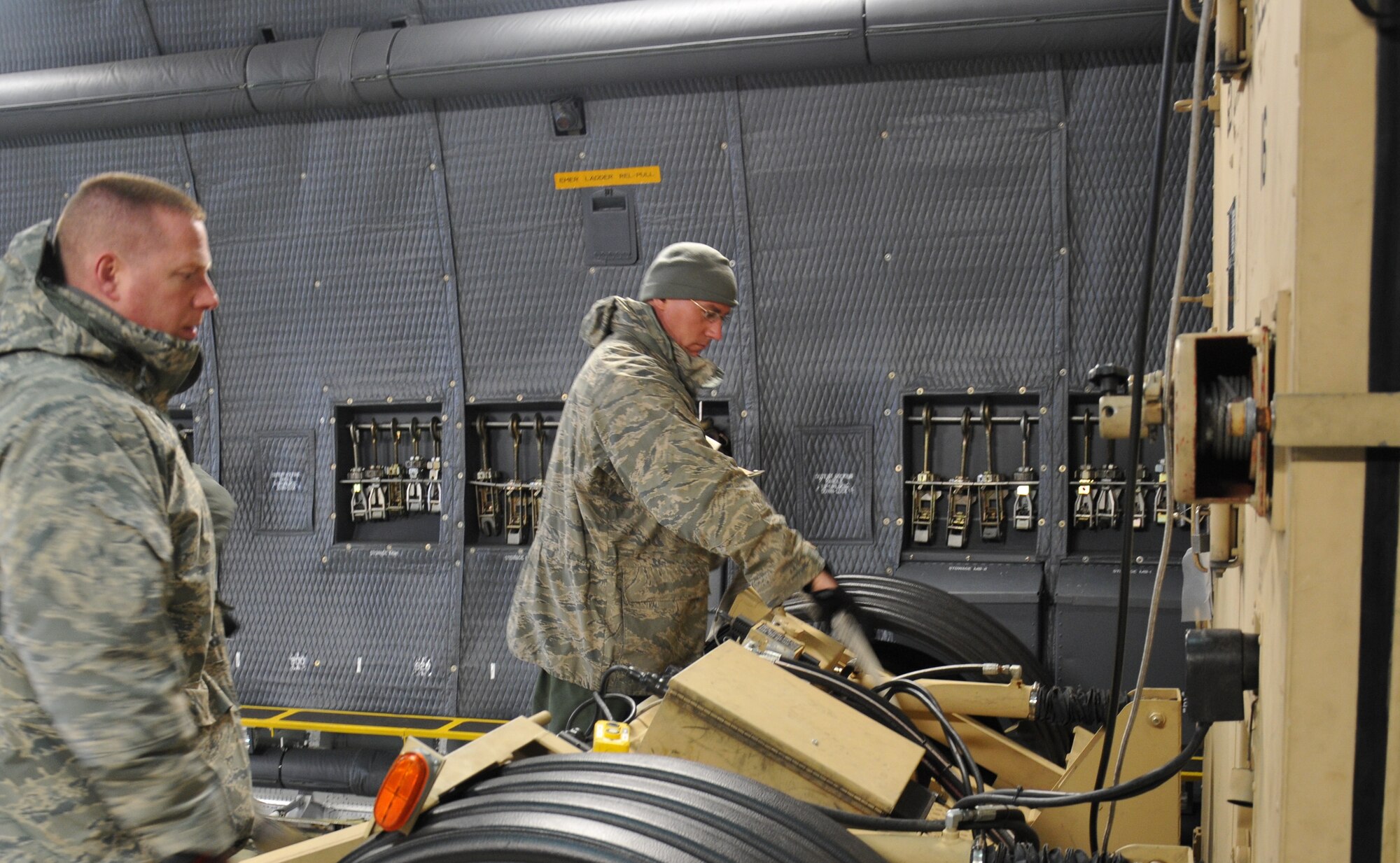 Tech. Sgt. Sean Ahearn (left) and Staff Sgt. Darryl Santry, 512th Airlift Control Flight radio frequency transmission specialist and loadmaster, assigned to Dover Air Force Base, Del., prepare the Hardside Expandable Light Air-Mobile Shelter to be unloaded from a C-5M Super Galaxy April 7, 2014, at Griffiss International Airport, Rome, N.Y. The 512th ALCF's four-man Reserve team and 40 active-duty Airmen from Joint Base McGuire-Dix-Lakehurst, N.J., used the HELAMS, a deployable and mobile command post, during a contingency response training event aligned under the East Coast Combat Operations Exercise. (U.S. Air Force photo/Senior Airman Joe Yanik)