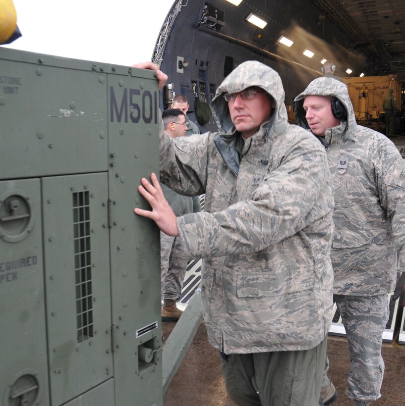 Staff Sgt. Darryl Santry (front) and Tech. Sgt. Sean Ahearn, 512th Airlift Control Flight loadmaster and radio frequency transmission specialist, assist in unloading a power generator from a C-5M Super Galaxy as part of the 2014 East Coast Combat Operations Exercise April 7, 2014, at Griffiss International Airport, Rome, NY. The contingency response training mission teamed reservists from Dover Air Force Base, Del., with active-duty Airmen from the 621st Contingency Response Wing, Joint Base McGuire-Dix-Lakehurst, N.J., to set-up command post operations in an austere airfield. (U.S. Air Force photo/Senior Airman Joe Yanik)